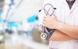 Doctor with a stethoscope in the hands and hospital background.